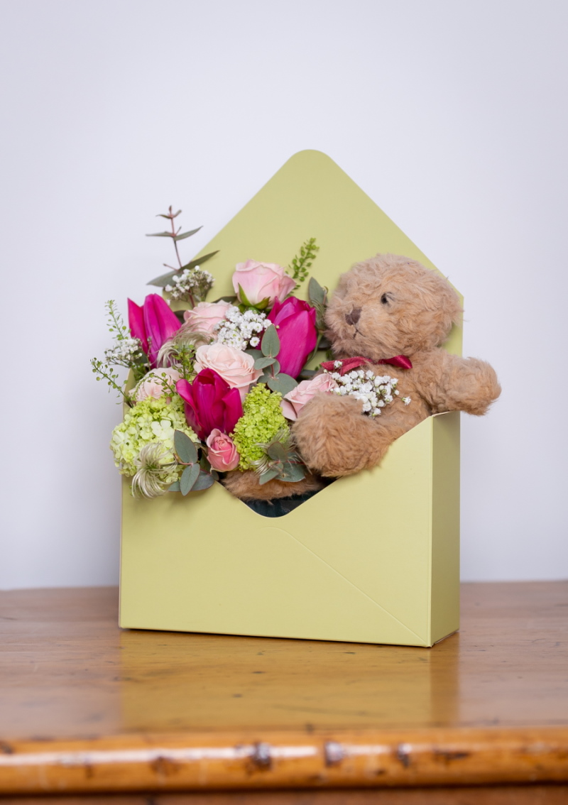 Mother's Day flowers in envelope box with pink flowers.