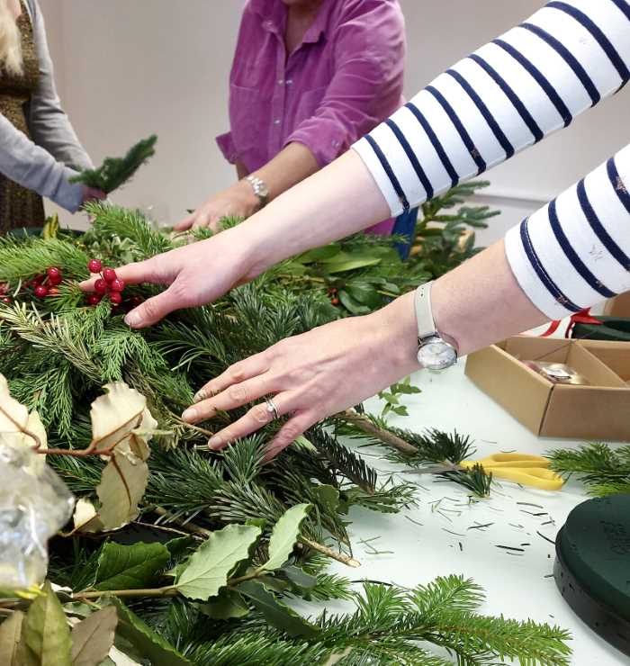 Making a Christmas wreath in a Christmas wreath making workshop.