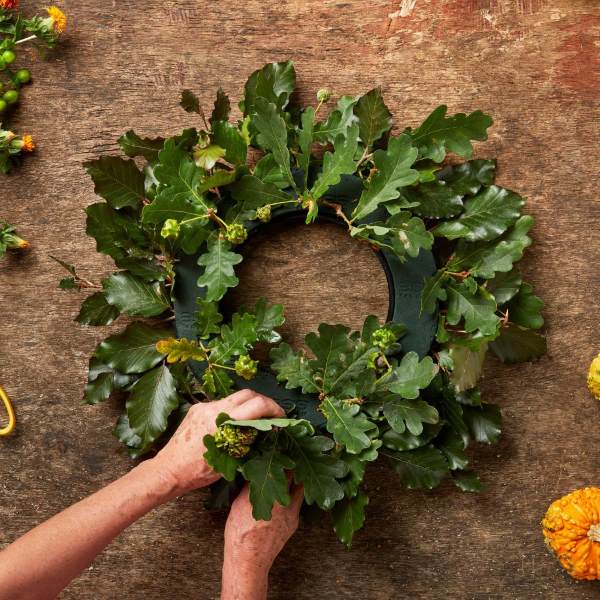 Adding foliage to an OASIS® Floral Foam halloween wreath