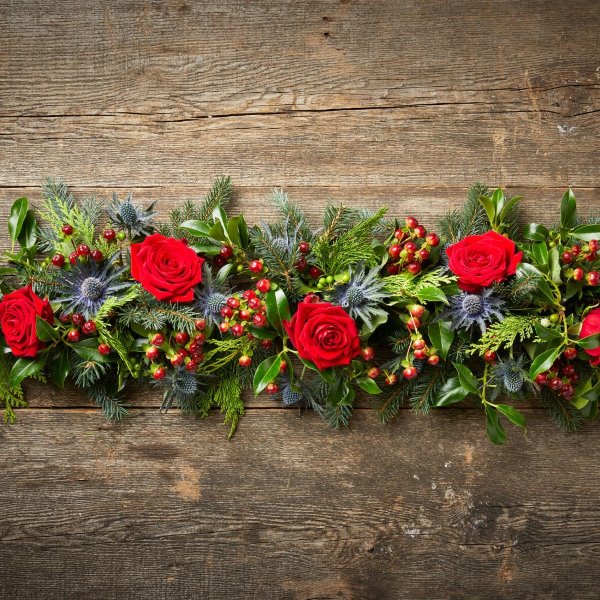 Festive floral garland with red roses and thistles 
