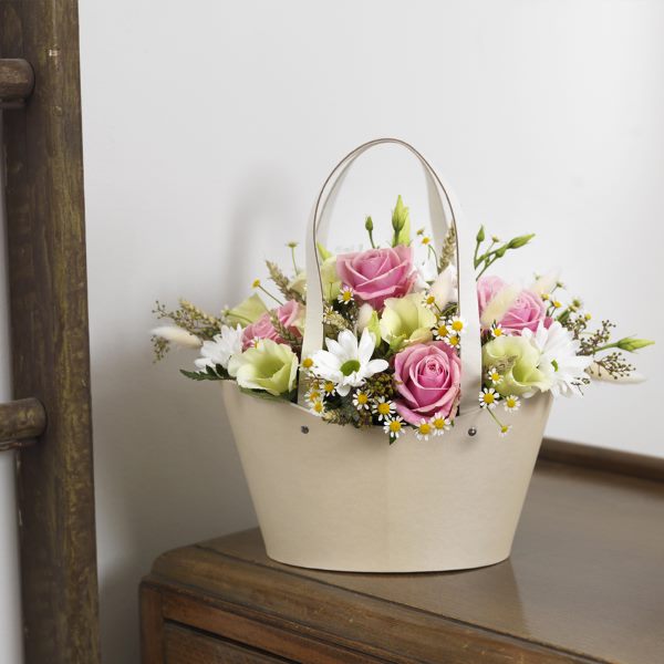 Cream Napier Bag with pretty floral arrangement featuring white daisies, pink roses and foliage.