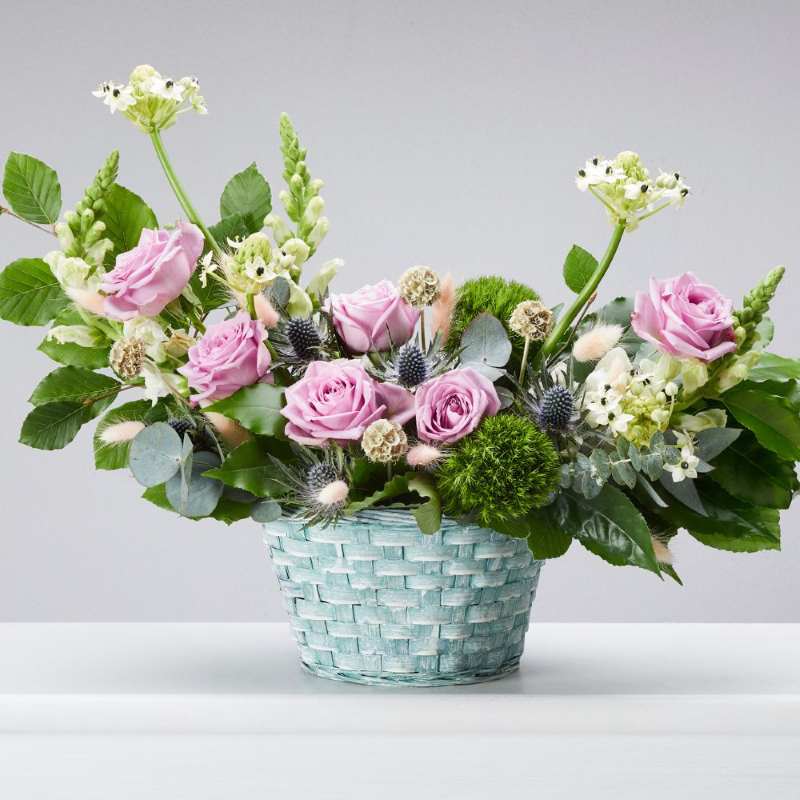 Light blue bamboo casi bowl with eucalyptus, thistles, pink roses and more.
