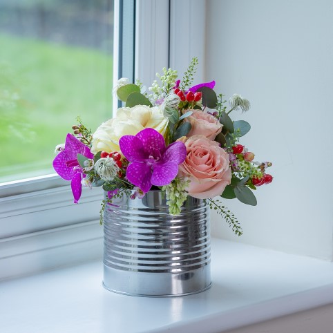Shiny Cylinder Pot with cream peonies, white roses, pale pink roses and eucalyptus.